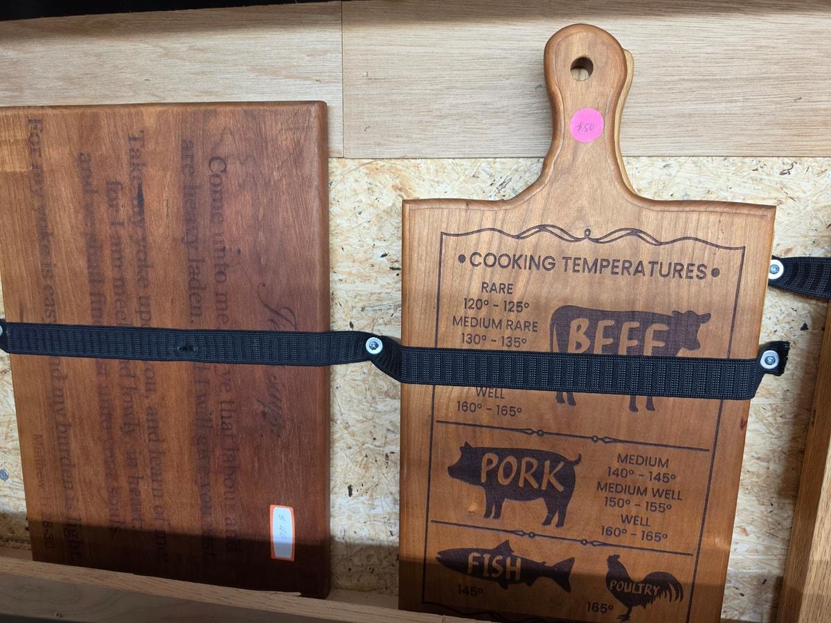 Wooden kitchen boards with engraved lettering displayed in Howard’s shop