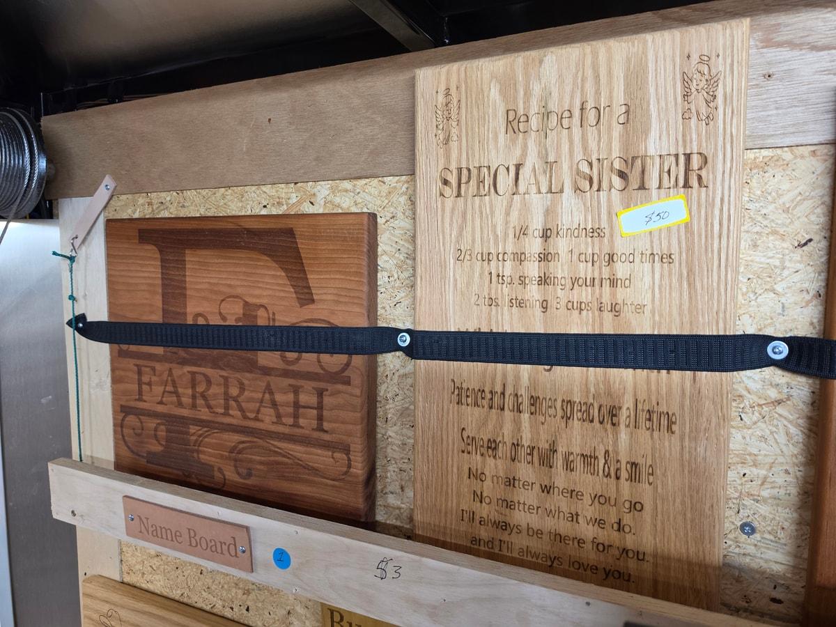 Wooden plaques including an engraved sister message and a framed personalized name board