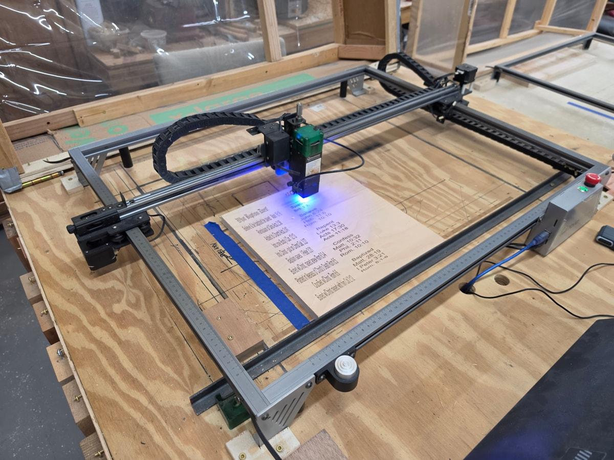 Laser engraving equipment working on a wooden board in the shop