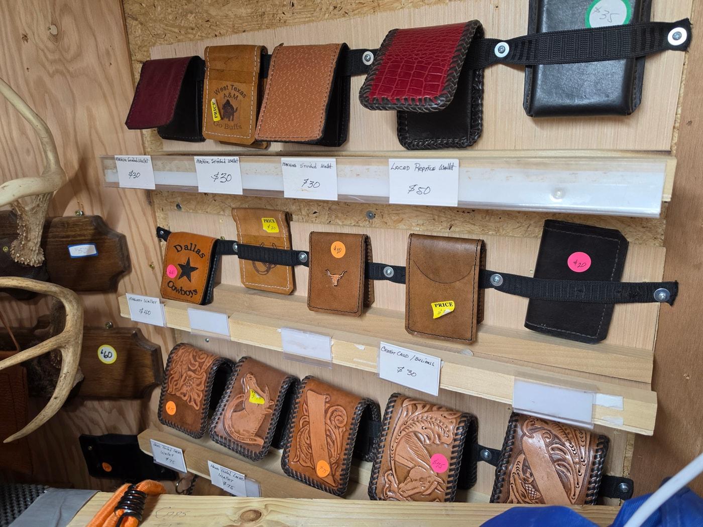 The shop shelves filled with tooled leather wallets, cases, and pouches