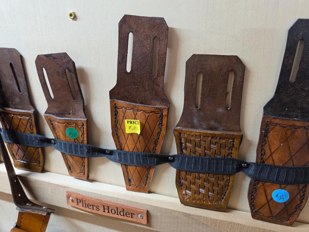 Brown leather pliers holders with belt slots and different tooled patterns
