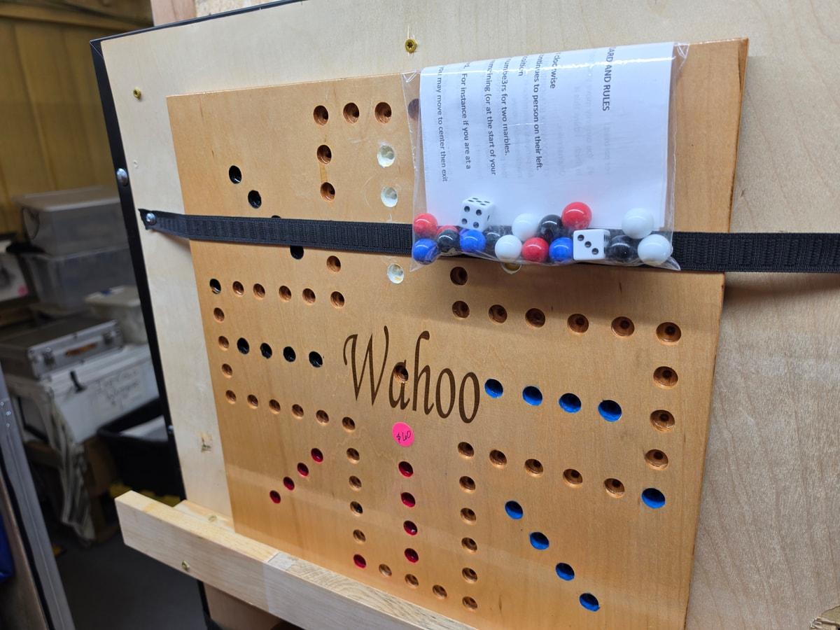 A wooden Wahoo game board with colored marbles on a display shelf